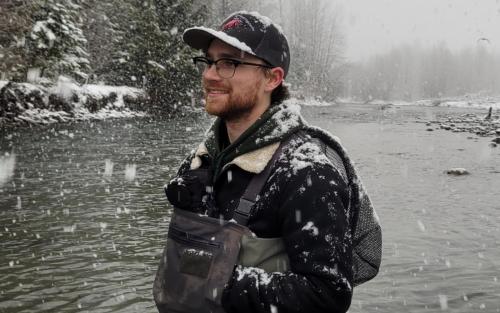 Student standing by a stream