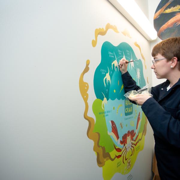 VIU student painting a mural