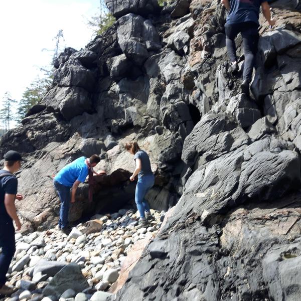Students examining deformed rocks on Quadra Island for GEOL206 field school