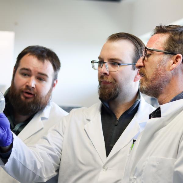 VIU students and professor looking at a microbiology sample