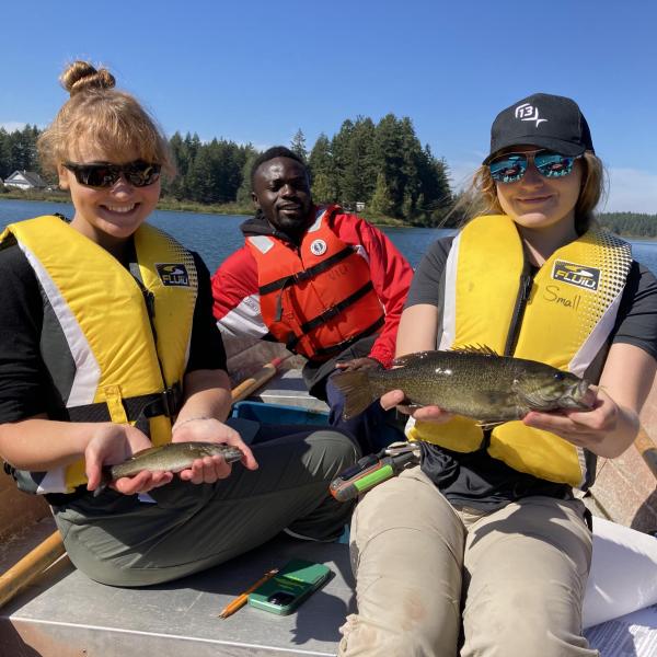 Fish & Aquaculture students in a boat holding fish