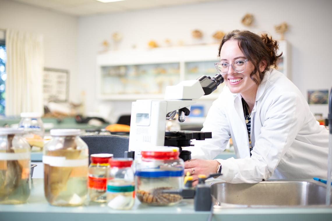 VIU student smiling at the microscope