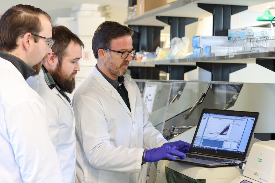 VIU students and professor looking at data in a lab