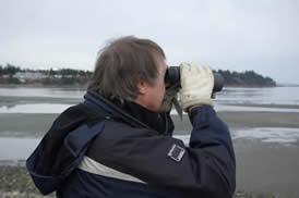RMOT Professor on the beach looking through binoculars
